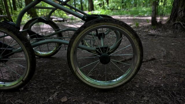 Wheels of the walking stroller on a forest pathway.