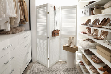 Dressing room interior with clothes rack and collection of stylish shoes