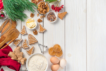 Gingerbread cookies, ingredients, and Christmas decorations on a white background.