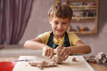 Kid sculpts clay crafts pottery school.
