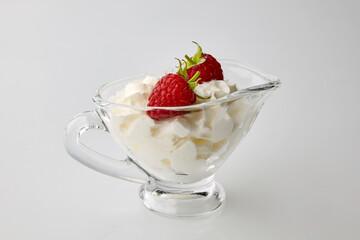 Two fresh raspberries in a glass bowl with cream