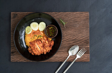 yellow rice with fried chicken on a black plate