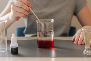 Lava lamp, science experiment with water, food coloring, oil and aspirin doing by school girl. Step by step process of doing homework. Education, back to school, distant concept.