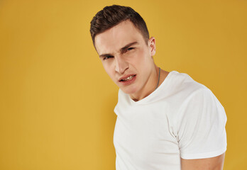 handsome man in white t-shirt confident look cropped view yellow background emotions