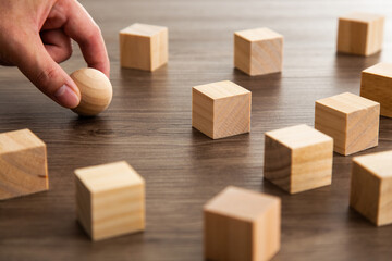 Closeup hand and wood sphere, try to find the right position