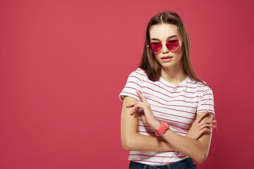 Fototapeta premium pretty woman wearing glasses striped tshirt styles posing pink background
