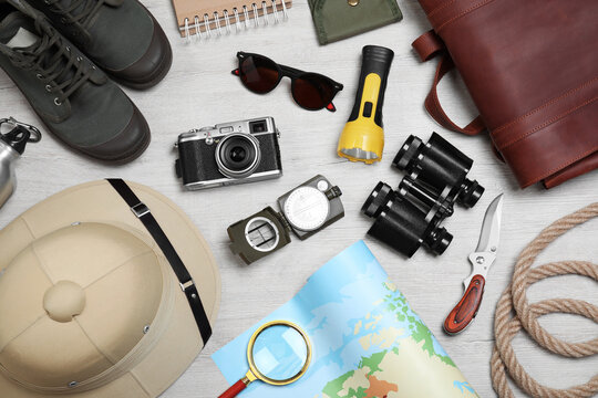 Flat lay composition with safari accessories on white wooden background