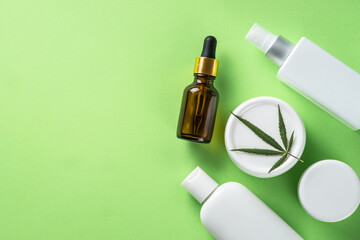 Cannabis cosmetic products. Natural cosmetic. Cream, soap, serum and others. Flat lay image on green background.