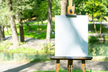 Empty white artist's canvas on the easel. Creative mockup background.