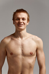 Fototapeta premium Young swimmer in excellent physical shape, on a gray background with copy space, call for sports, advertising banner