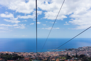 Spectacular image of the sea, taken from inside the cable car of Funchal, Madeira, with a beautiful blue sky, and being able to see the cables where the cable car slides.