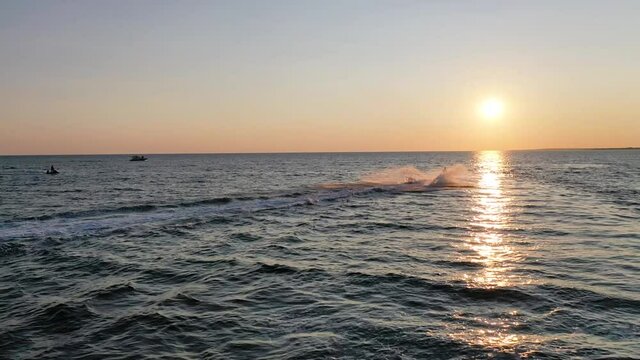 Beautiful turn of a water scooter on the sea at sunset