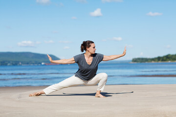 Fototapeta premium Woman praticing tai chi chuan on the beach. Chinese management skill Qi's energy. solo outdoor activities. Social Distancing 