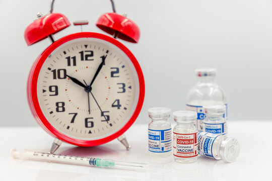 Covid Vaccine Dose Bottle With Time Clock For Coronavirus Vaccination Timing Concept.