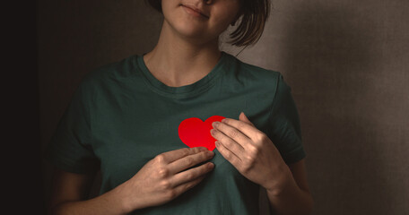 Young girl with red heart. Happy teenage giving her love concept banner photo