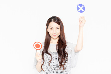 NGのプラカードを持って立っているカジュアルな服装の女性