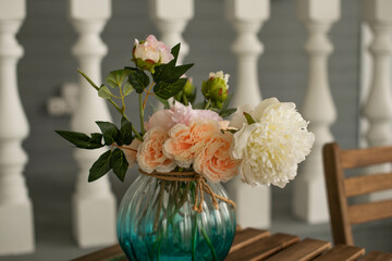 Pink and white peonies in a glass vase on a table