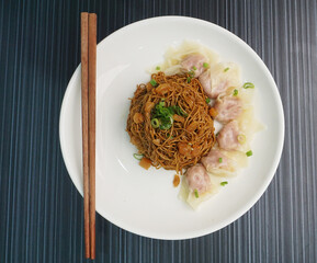 stir fried dry wanton noodle mee with meat dumpling on dark grey wood background dim sum halal menu