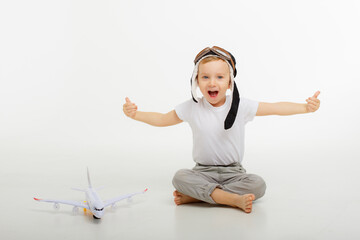 little boy in a pilot's hat and with an airplane on a white background