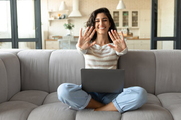 Take a break. Happy young lady with laptop directing both palms at camera, making pause in online...
