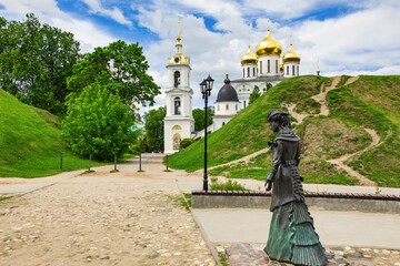 Genre sculpture "Teacher" against the background of the ramparts of the Dmitrov Kremlin on a sunny, warm summer day. Dmitrov, Moscow Region, Russia-July 2021