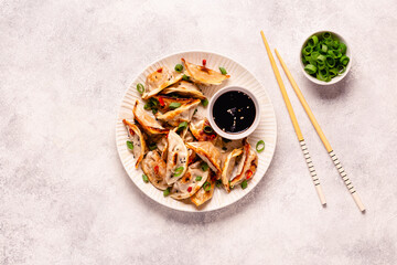 Fried dumplings served with green onions, sesame seeds and chili peppers