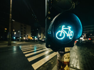 green light of bicycle traffic light on night city crossroad