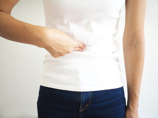 Asian woman abdominal pain due to gallbladder stones on white background. closeup photo, blurred.