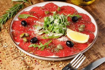 Beef Carpaccio With Parmesan, Capers, Frugula On White Plate
