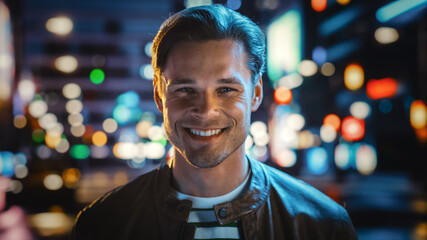 Portrait of Handsome Blonde Man Smiling, Looking at Camera, Standing in Night City with Bokeh Neon...