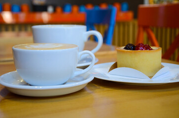 cappuccino in a white mug and vanilla cheesecake