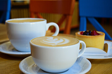 cappuccino in a white mug and vanilla cheesecake