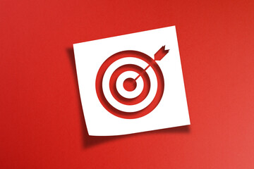 Note paper with target sign on red background	