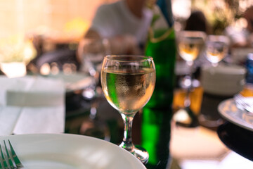 Glass of cold drink on a table in a restaurant with drops of cold water on the walls of the glass