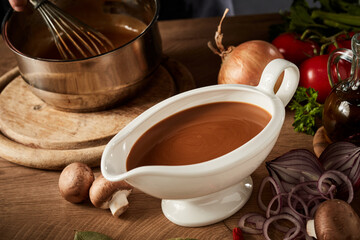 Gravy boat with serving of delicious rich brown sauce or gravy - obrazy, fototapety, plakaty