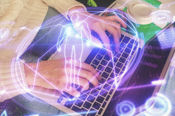 Double exposure of woman hands typing on computer and general theme hologram drawing. Education concept.