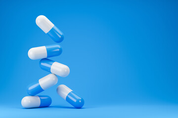 Heap of blue and white capsules of pills on a blue background. Side view. 3D rendering