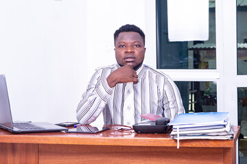 portrait of a young businessman with laptop in the office, serious