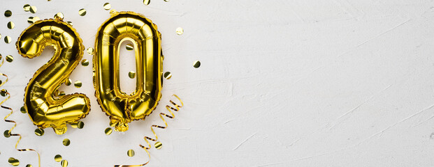 golden foil balloon number twenty. Birthday or anniversary card with the inscription 20. gray concrete background. - obrazy, fototapety, plakaty