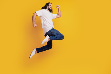 Fototapeta na wymiar Profile portrait of energetic crazy funny cheerful guy run fast rush jump on yellow background