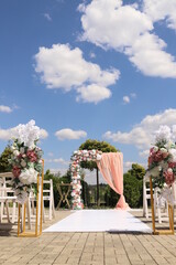 Obraz na płótnie Canvas Wedding arch decorated with flowers outdoors