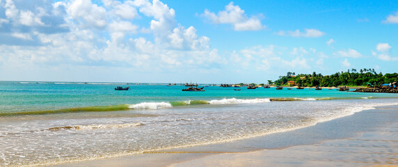 tropical beach and blue sea and white fluffy clouds. Wide photo.