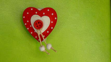 wooden heart on green background