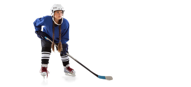 Full-length portrait of child girl hockey player isolated over ice rink