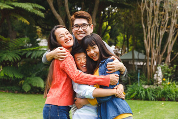 Portrait of happy asian parents, son and daughter smiling outdoors in garden