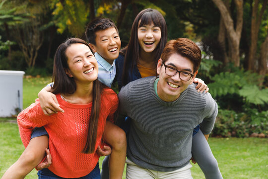 Portrait of happy asian parents, son and daughter smiling outdoors in garden