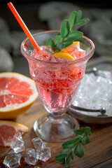 Fruit cocktail, in a glass with natural healthy fruits on a table with kitchen accessories.