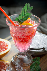 Fruit cocktail, in a glass with natural healthy fruits on a table with kitchen accessories.