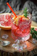 Fruit cocktail, in a glass with natural healthy fruits on a table with kitchen accessories.