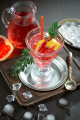 Fruit cocktail, in a glass with natural healthy fruits on a table with kitchen accessories.